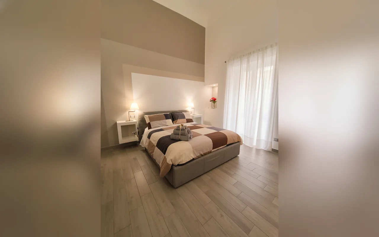 La camera matrimoniale con la finestra e le tende chiare