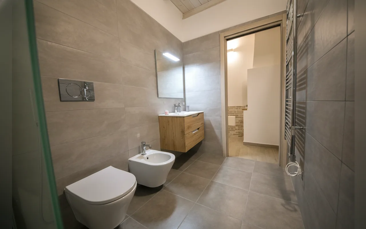 Il bagno visto d'insieme, con doccia e sanitari sospesi