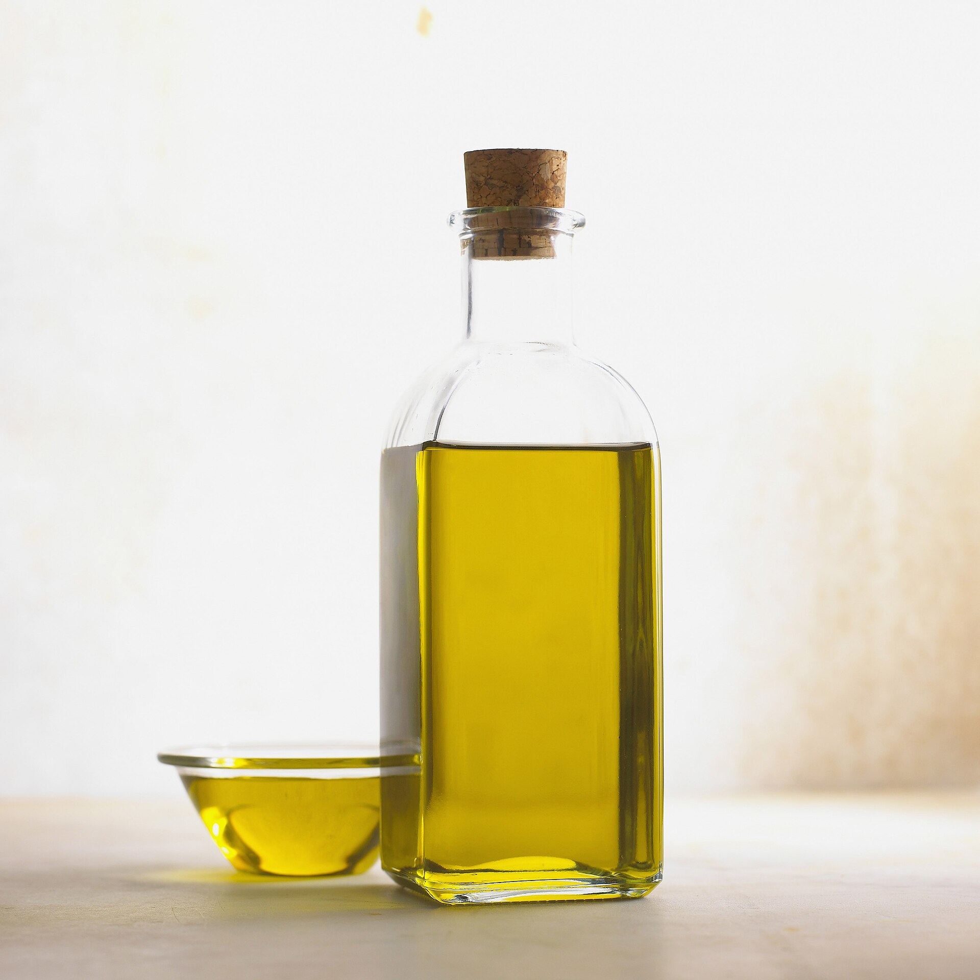 Olio extravergine di oliva appena franto versato in una bottiglia